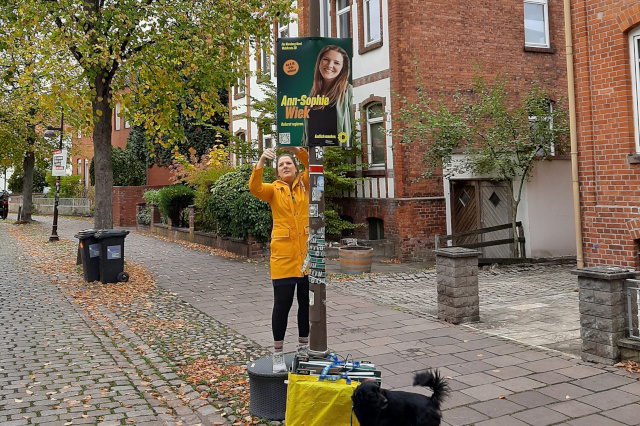 Ann-Sophie Wiek hängt eines ihrer Kopfplakate ab